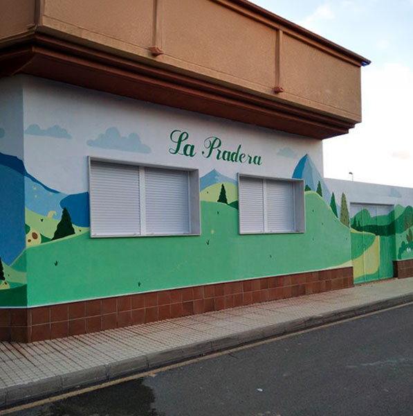 Fachada principal de guardería con paisages y dibujos infantiles