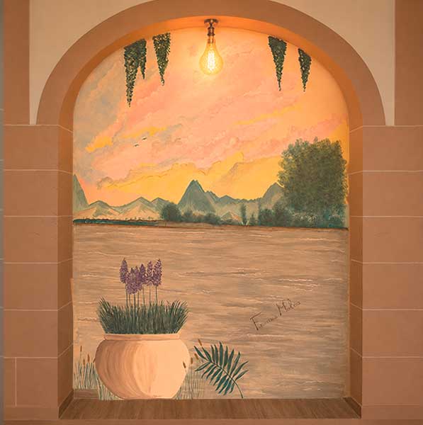 Mural paisajístico enmarcado por un arco interior